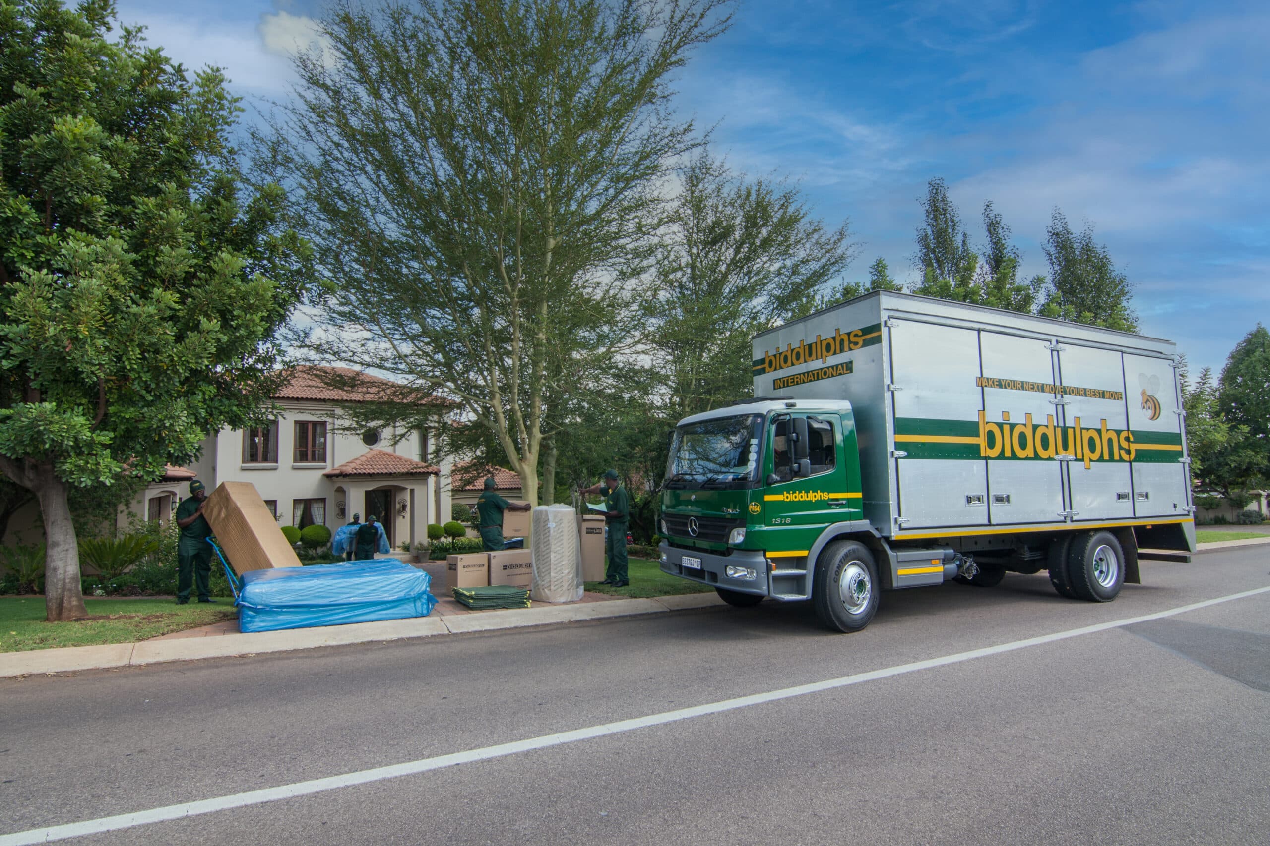 Biddulphs moving team loading furniture into a truck outside a family home